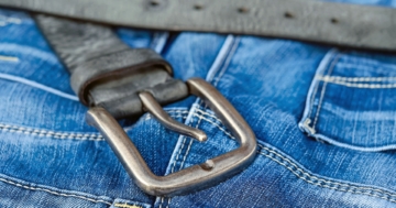 Eine Jeans mit einem schwarzen Ledergürtel und einer stählernen Schnalle, die den sogenannten „Wodkagürtel“ symbolisiert.