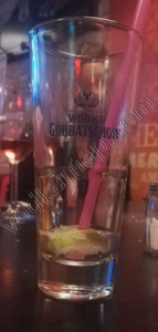 Gorbatschow Wodka Ein leeres Glas mit einem Strohhalm steht vor einem schlichten, eleganten Hintergrund.